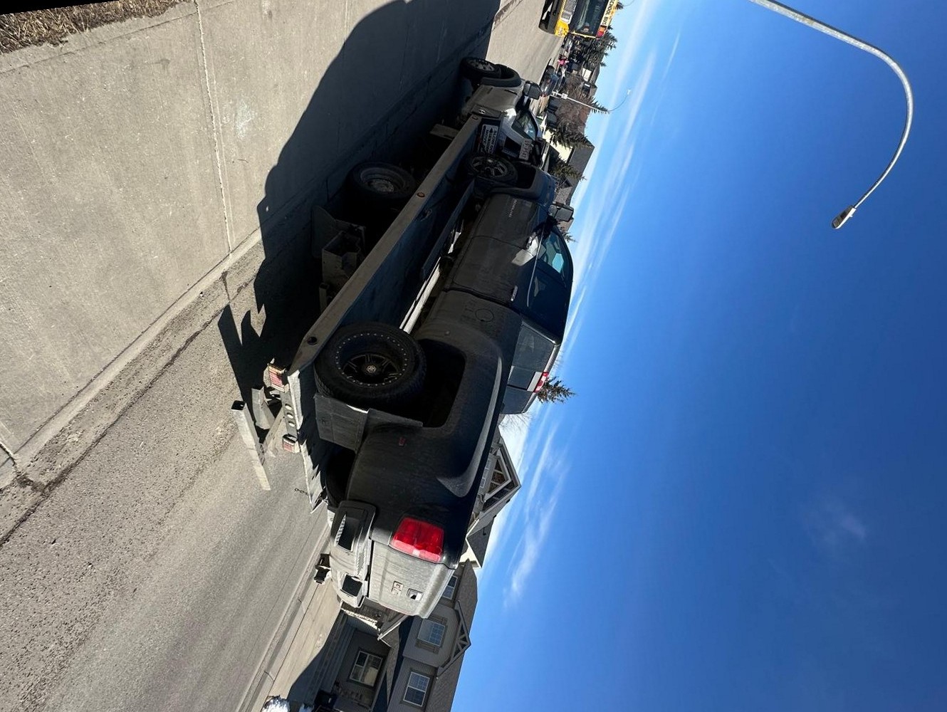 AR Towing flatbed truck hauling a pickup down a Calgary street